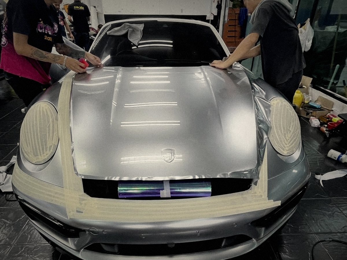 Paint protection film being applied to a Porsche front end